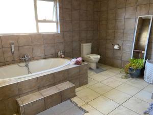 La salle de bains est pourvue d'une baignoire et de toilettes. dans l'établissement Nambani House, à Windhoek