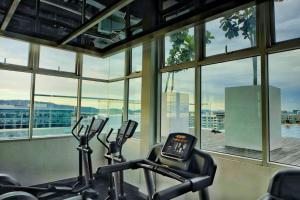 een fitnessruimte met 2 hometrainers in een kamer met ramen bij Morning Tiffany / Opposite IMAGO / KK City Center in Kota Kinabalu