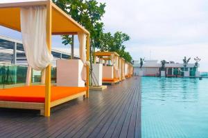 een rij bedden op een terras naast een zwembad bij Morning Tiffany / Opposite IMAGO / KK City Center in Kota Kinabalu