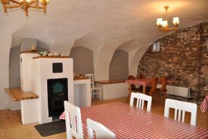 a dining room with a fireplace and a table and chairs at Penzion Rankl-Sepp in Stachy