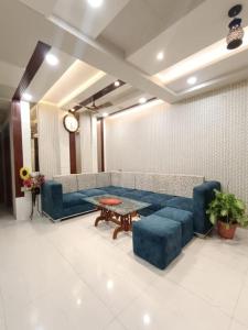 un soggiorno con divano blu e tavolo di STAY DAILY INN a Varanasi