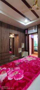 um quarto com uma grande cama rosa e um cobertor rosa em STAY DAILY INN em Varanasi