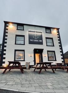 a building with two picnic tables in front of it at The Canal in Whatstandwell