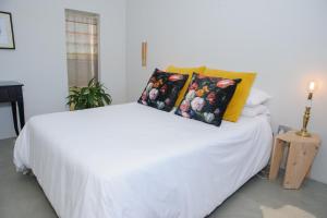 um quarto com uma cama branca e 2 almofadas em Oranje Meul em Paarl