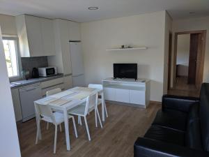 uma cozinha e sala de estar com mesa e cadeiras em Casas do Corgo em Vila Real