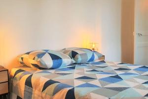 um quarto com uma cama com almofadas em Cocon Rue Ecuyère - Calme- 2ch - 6pers em Caen