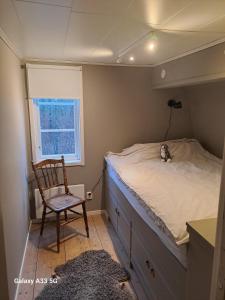 LinnerydにあるBastanäs Rosenbergのベッドルーム1室(ベッド1台、椅子、窓付)