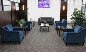 una sala de espera con sillas y mesas azules en Radisson Hotel Montreal Airport, en Saint-Laurent