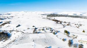une vue aérienne sur une piste de ski dans la neige dans l'établissement Les Genêts du Sancy, à Besse-et-Saint-Anastaise