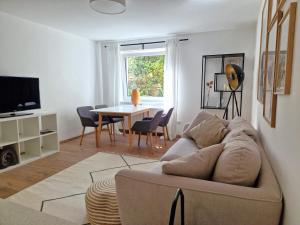 a living room with a couch and a table at Magnolia: Moderne, voll möblierte Wohnung in Bietigheim-Bissingen