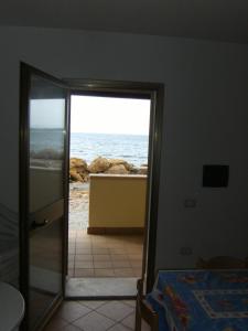 um quarto com vista para o oceano através de uma porta em RESIDENCE LA DARSENA em Isola di Capo Rizzuto