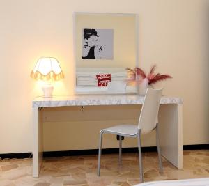 una scrivania con lampada e sedia bianca di Elizabeth House a Como