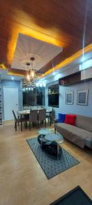 een woonkamer met een bank en een tafel bij 2BR, BIG & COZY UNIT 592sqft at TORRE DE MANILA in Manilla