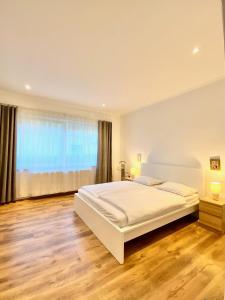 a bedroom with a large bed and a large window at Luca Apartman in Gyenesdiás