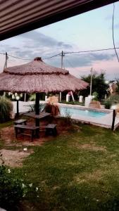 einen Pavillon mit einem Picknicktisch neben einem Pool in der Unterkunft El Rincon de Jose Luis - Cabañas y Restaurante in Tanti