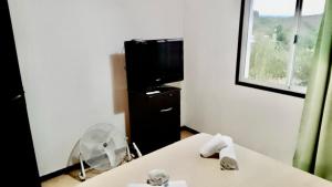 Zimmer mit einem Tisch, einem Ventilator und einem TV. in der Unterkunft El Rincon de Jose Luis - Cabañas y Restaurante in Tanti