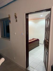 a room with a door leading to a bedroom with a bed at T3 meublé Chez Diouma in Dakar