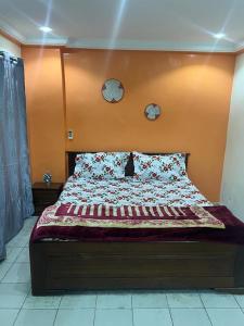 a bed in a bedroom with two clocks on the wall at T3 meublé Chez Diouma in Dakar