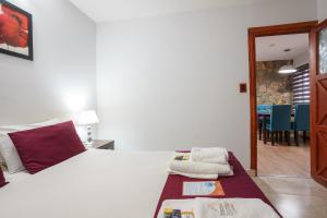 um quarto com uma cama branca e uma sala de jantar em Cabañas Tierra Mistica em Ushuaia