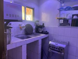 a small kitchen with a sink and a stove at T3 meublé Chez Diouma in Dakar