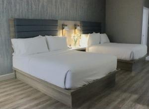 um quarto com 2 camas e almofadas brancas em Radisson Hotel Montreal Airport em Ville Saint Laurent