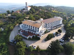 uma vista superior de um grande edifcio com carros estacionados na frente em Hotel Senhora do Castelo em Mangualde