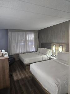 a hotel room with two beds and a window at Radisson Hotel Montreal Airport in Ville Saint Laurent