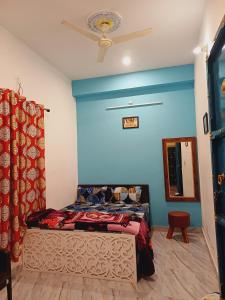 a bedroom with a bed with a blue wall at The Mehran way Homestay in Jodhpur