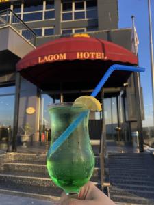 osoba trzymająca zielonego drinka z niebieską słomką w obiekcie Lagom Hotel w mieście Edirne