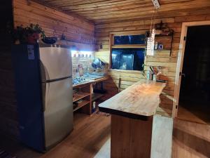 een keuken met een koelkast en een aanrecht in een cabine bij Cabaña Familiar in Compu