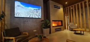 a living room with a tv and a fireplace at Aparthotel Zlatni Javor in Jahorina