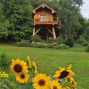 a tree house with sunflowers in front of it at La quiete di Ileana Sofian in Pamparato