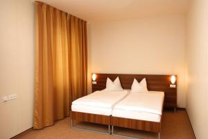 a bedroom with a bed with white sheets at Hotel Arman in Nižná