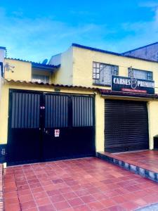 um edifício com duas portas de garagem e um sinal nele em A 5 minutos del Aeropuerto el Dorado em Bogotá