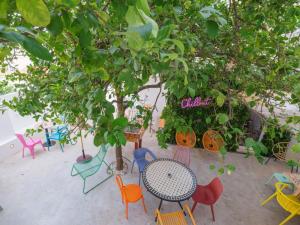 un grupo de coloridas sillas y mesas bajo los árboles en Lisbon Chillout Hostel, en Lisboa