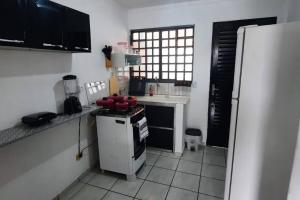 a small kitchen with a stove and a refrigerator at Chalé 17 in Campo Grande