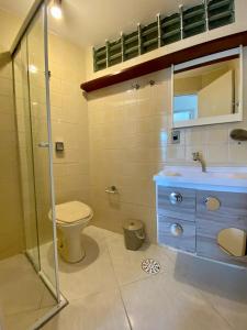 a bathroom with a toilet and a sink and a shower at APTO DE FRENTE PARA O MAR - CARAGUATATUBA. in Caraguatatuba