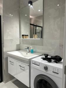 a white bathroom with a washing machine and a sink at Anka recidence in Istanbul