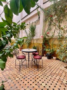 a patio with a table and chairs and plants at Riad Zahraa Al Ismailia in Meknès
