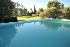 een zwembad met blauw water in een tuin bij Melton Wold Guest Farm in Meltonwold