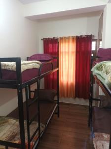 una stanza con tre letti a castello e una finestra di Him Aaranya Home stay Shimla a Shimla