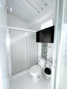 a bathroom with a toilet and a glass shower at Apartaestudio Luiggis Cucuta in Cúcuta