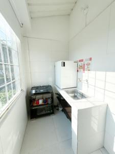 a white kitchen with a sink and a microwave at Apartaestudio Luiggis Cucuta in Cúcuta
