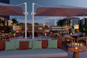 a couch sitting on a patio with tables and umbrellas at Residence Inn by Marriott Santiago de los Caballeros in Santiago de los Caballeros