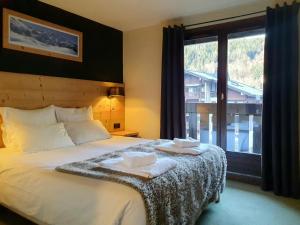 una camera da letto con un grande letto con asciugamani di Chalet Hôtel du Bois a Les Houches