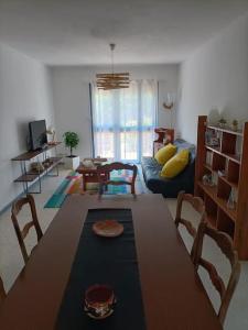 uma sala de estar com uma mesa e um sofá em Grande maison 3 chambres - Jardin, terrasse et parking - Bord de mer em Torreilles