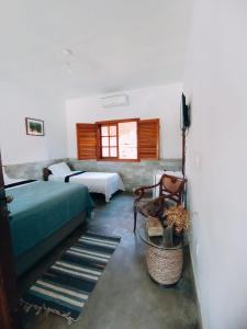 a bedroom with two beds and a couch and a window at Recanto Rocas in Pirenópolis