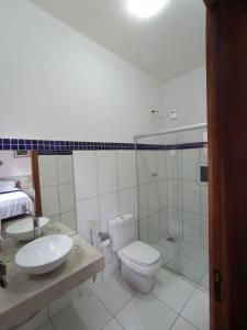 a bathroom with a toilet and a sink and a shower at Recanto Rocas in Pirenópolis