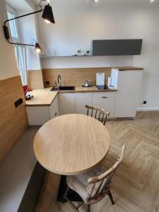 uma cozinha com uma mesa de madeira e 2 cadeiras em CityCenterApartments/KSS2 em Bielsko-Biala