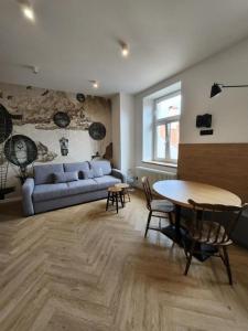 ein Wohnzimmer mit einem blauen Sofa und einem Tisch in der Unterkunft CityCenterApartments/KSS2 in Bielsko-Biała